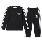 Boy wearing black Adidas summer two-piece coord set for ages 1 to 12, featuring lightweight fabric and sporty style.